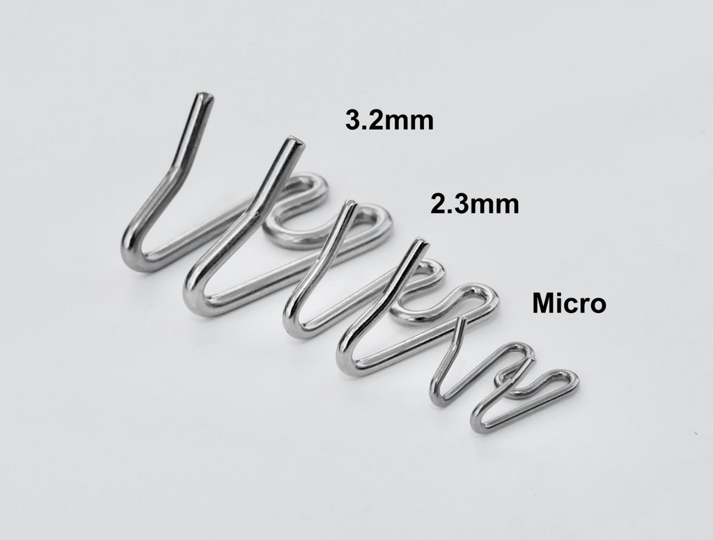 Metal dog training prongs with labeled sizes on a white background